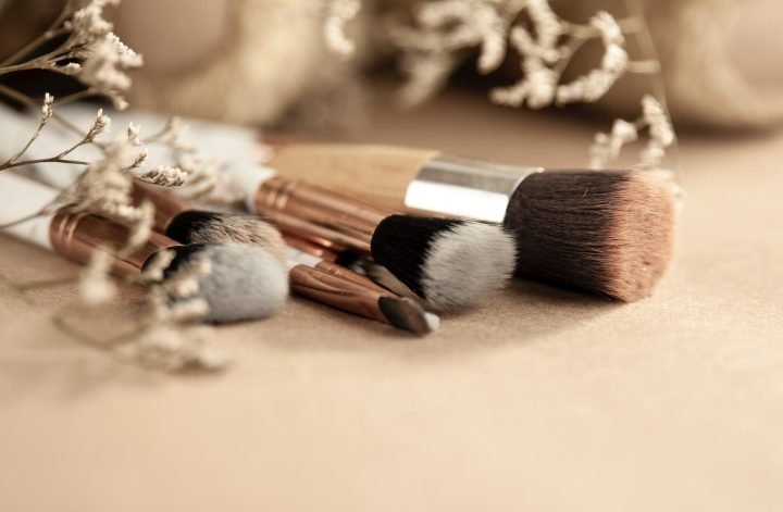 different makeup brushes and dried flowers